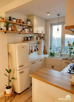 a white refrigerator freezer sitting inside of a kitchen next to a sink and stove