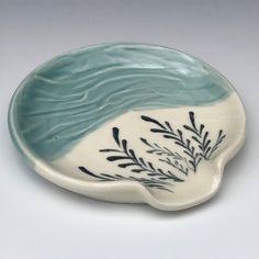 a white and blue dish with black designs on it