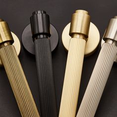 four different types of brass and black handles on a black surface with gold trimmings