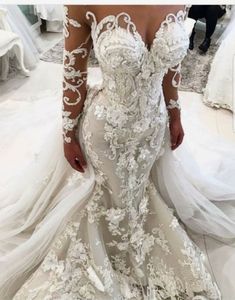 a woman wearing a wedding dress with long sleeves