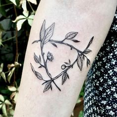 a black and white photo of a branch with leaves on it's arm, in the shape of a heart