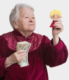 an elderly woman holding up a doll and money