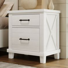 a white nightstand with two drawers on top of it