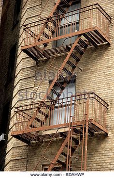 a fire escape on the side of a brick building with metal railings and balconies