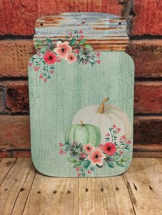 a painted metal canister sitting on top of a wooden table next to a brick wall