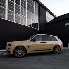 a beige car parked in front of a building