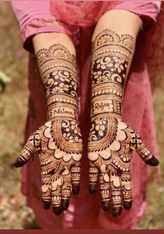 two hands with henna tattoos on them