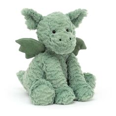 a green dragon stuffed animal sitting on the ground