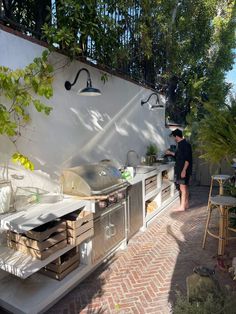 a man standing in front of an outdoor kitchen