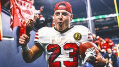 a man holding a football in his right hand while wearing a red and white uniform