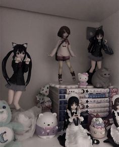 there are many dolls on top of the books