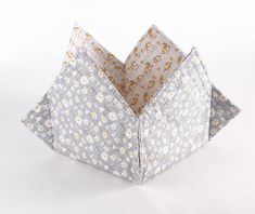 an origami flowered box is open on a white surface with yellow flowers