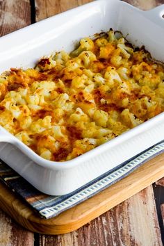 a casserole dish with cheese and onions in it sitting on a wooden table