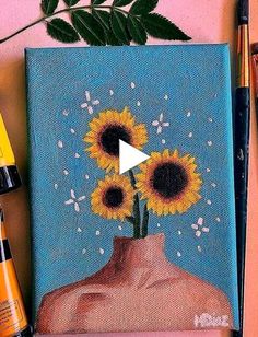 a painting with sunflowers on it next to some markers and paintbrushes