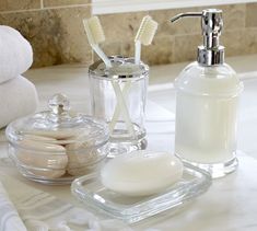 bathroom accessories including soap, toothbrushes and other items on a marble countertop