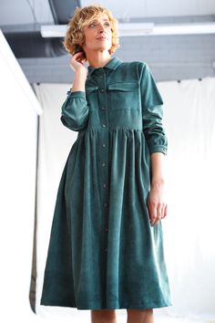 "Shirt dress in a soft needle cord fabric. Loosely fitted, below the knee length, buttons through closure, front pockets on the chest. - Handmade in our studio from 96% cotton 4% spandex - Loose fit - Shirt collar - Long sleeves with the cuff and button - Large chest pockets - Side seem pockets - Button closure - Hand ruffled skirt FABRIC&CARE 96% cotton 4% spandex. Hand wash or gently machine washable 30oC, hang dry recommended, iron on low. SIZE&FIT Simona is wearing petrol color dress Petrol Color, Loose Fit Shirts, Ruffled Skirt, Corduroy Dress, Color Dress, Ruffle Skirt, Shirtdress, Sustainable Clothing, Denim Outfit