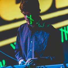 a man standing in front of a laptop computer on top of a table next to a microphone