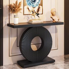 a black console table with an art piece on top and a blue rose in the middle