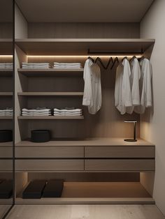 an empty walk in closet with clothes hanging on the shelves and lights on the ceiling