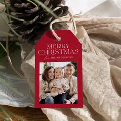 a merry christmas card with a photo on it and pine cone in the back ground