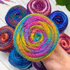 someone is holding yarn in their hand and it looks like they are made from different colors