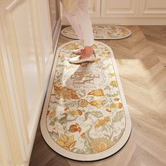 a woman standing on the floor in front of two rugs that have flowers on them