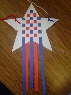 an origami star with red, white and blue strips attached to it on a wooden table