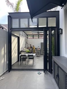 a person sitting at a table in the middle of a room with an open door