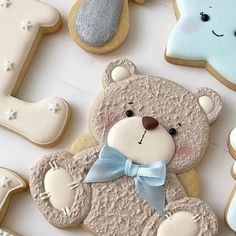 decorated cookies with teddy bears and stars are arranged in the shape of letter i on a table