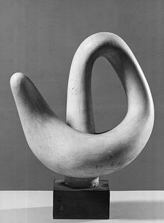 a black and white photo of a sculpture on a stand with one curved object in the middle