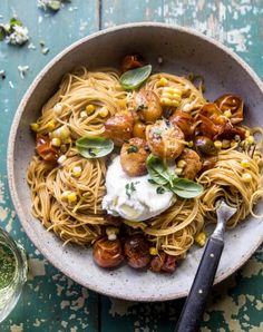 a bowl filled with pasta and vegetables on top of a table