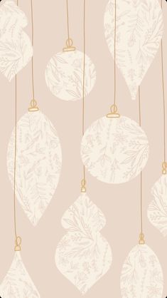 christmas ornaments hanging from strings on a pink background