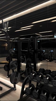 there are many gym equipment in this large room with lights on the ceiling and floor