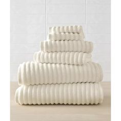 a stack of white towels sitting on top of a wooden table