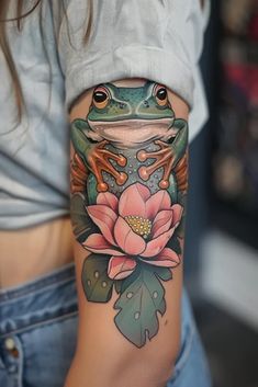 a woman's arm with a frog and flower tattoo on it