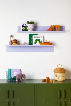 two shelves with books and toys on them in a children's playroom area