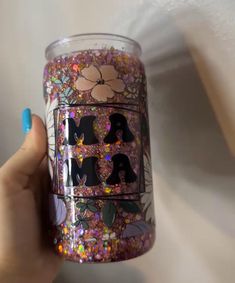 a hand holding up a cup with glitter on it