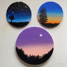 three painted coasters with trees and the moon in the sky above them on a white surface