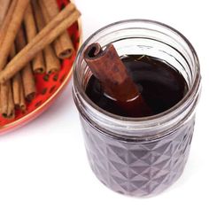 an image of cinnamon sticks and syrup in a glass jar on a plate next to it