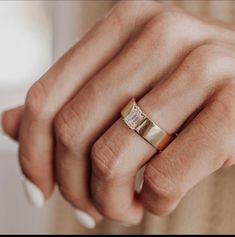 a woman's hand with a gold ring on her left and a diamond in the middle