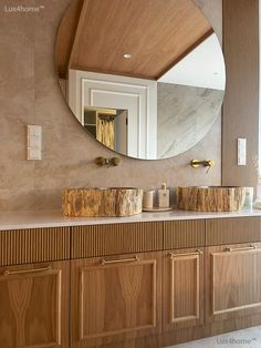 a bathroom with wooden cabinets and a round mirror