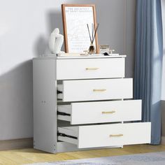 a white dresser with three drawers next to a window