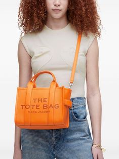 Looking for a splash of fun in your accessory collection? This vibrant little number is a must-have for those who love a pop of color with their practicality. Perfect for those on-the-go moments, it’s both chic and versatile. Tangerine orange leather for a bold statement Convenient logo print at the front and patch at the back Two rounded handles and adjustable shoulder strap for versatility Internal logo plaque and pocket to keep your essentials organized Top zip fastening for added security Marc Jacobs Tote Bag, Marc Jacobs Tote, Small Tote Bag, The Medium, Orange Bag, Leather Cap, Medium Tote, Small Tote, Mini Tote