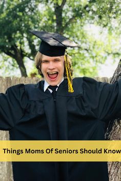 a young man wearing a graduation cap and gown with his arms out in the air