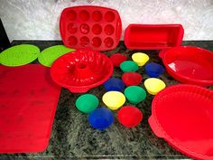 a table topped with red plastic plates and bowls