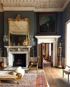 a living room filled with furniture and a fire place under a painting on the wall