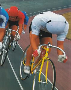 two bicyclists riding down the road on their bikes