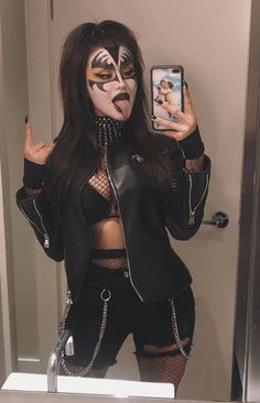 a woman with makeup on taking a selfie in front of a mirror wearing a black jacket