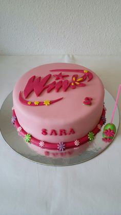 a pink cake sitting on top of a white table