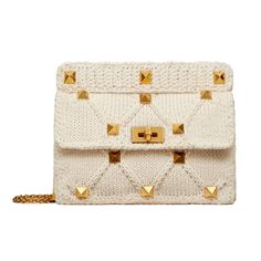 Introducing the Valentino Garavani Roman Stud large shoulder bag, meticulously crafted from ivory knitted cashmere. The neutral hue and soft texture paired with the iconic gold Roman Stud detailing exudes an edgy charm. Store your essentials in the spacious interior that includes a zipper and slip pocket. Elevate your look with the timeless allure of the ivory knit cashmere Roman Stud shoulder bag, only from Valentino Garavani.    Model: WW2B0I60ZDA  Roman Stud detailing    Ivory knitted cashmer Knitted Bag, Crochet Shoulder Bag, Large Shoulder Bags, Knitted Bags, Knit Cotton, Michael Kors Monogram, Giorgio Armani, Crossbody Shoulder Bag, Chain Strap